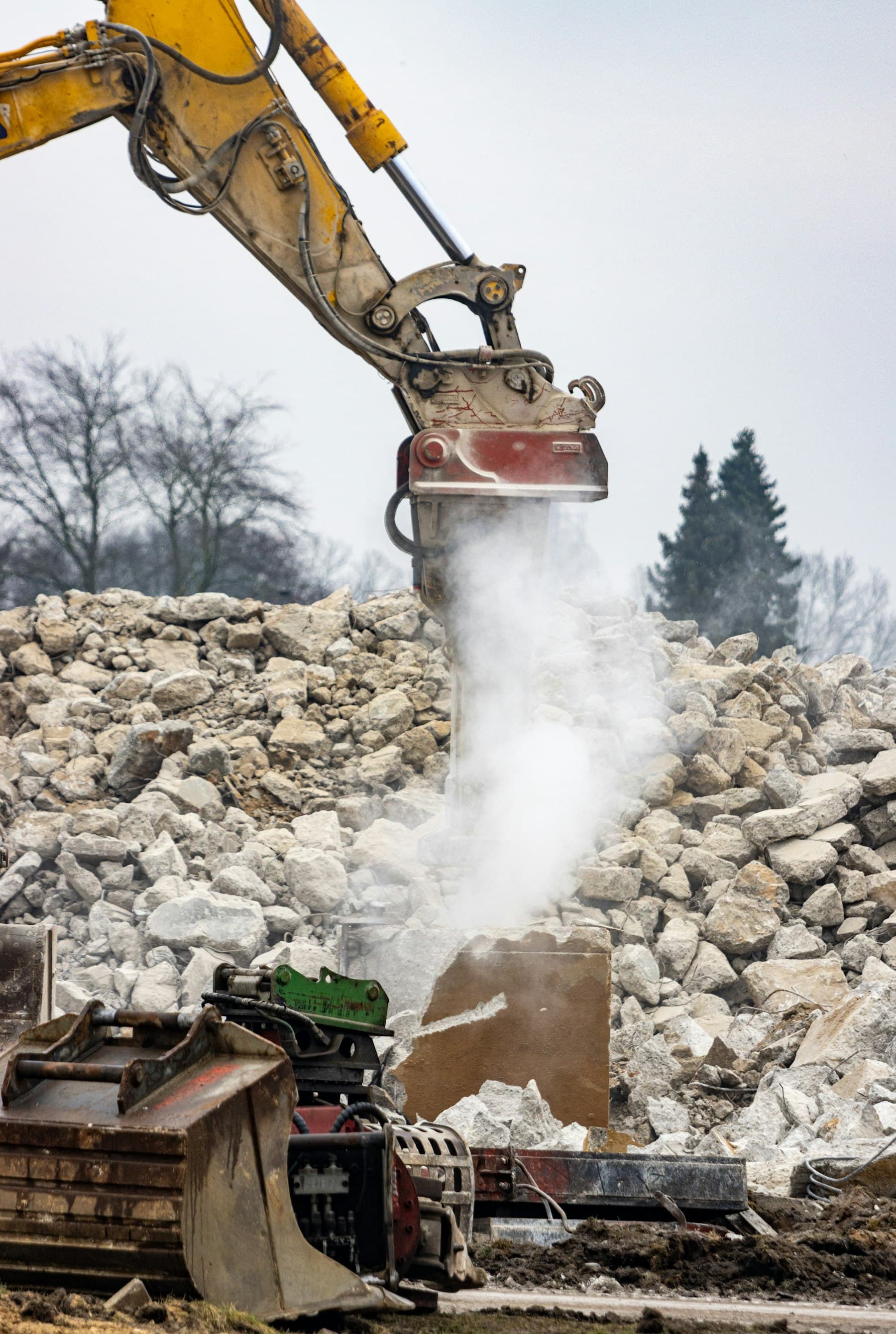 Hydraulikhammer zerkleinert Betonbruch auf einer Abbruchfläche